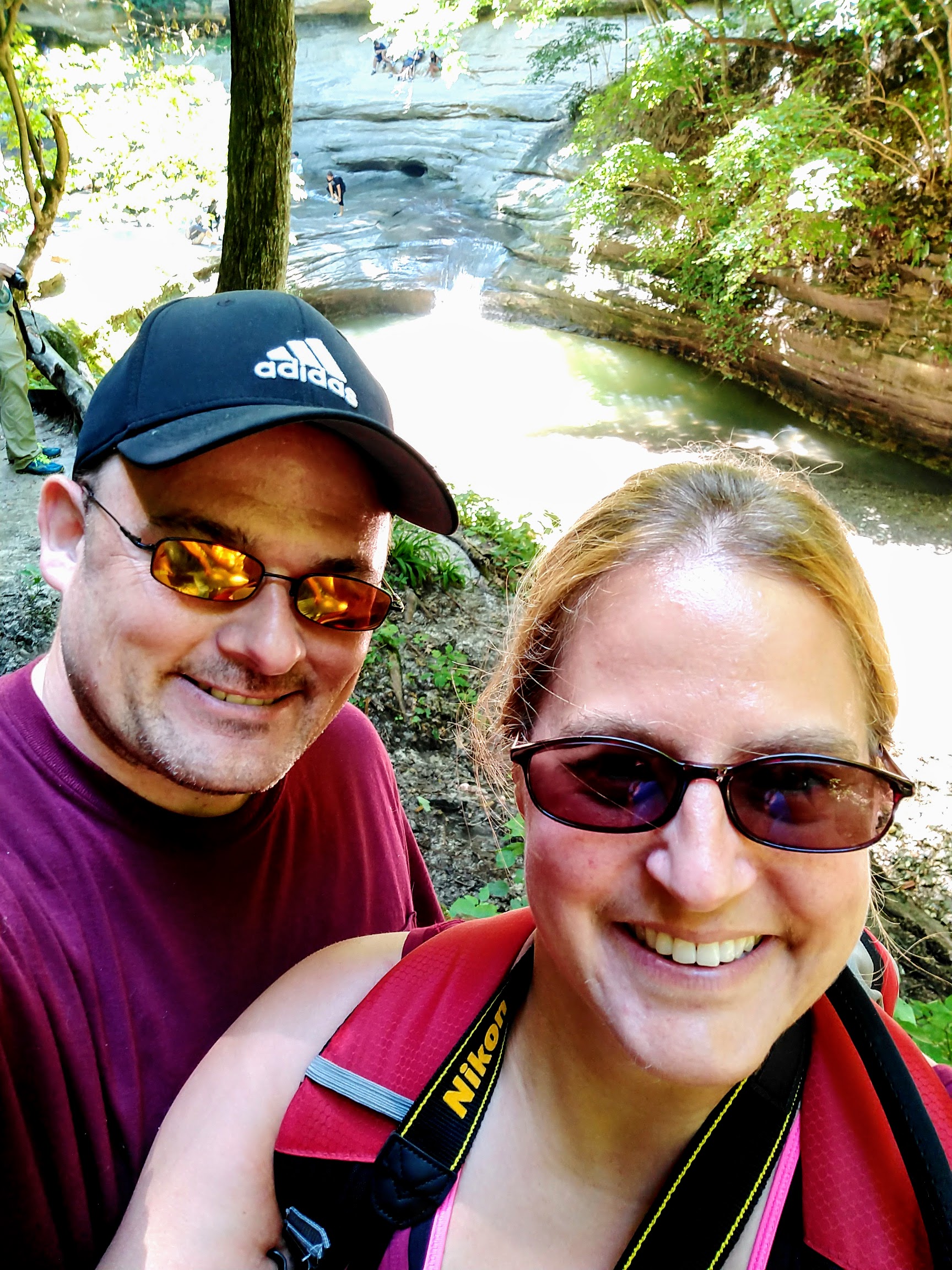 Britta and Matthew Brossard on a hiking trail near a waterfall, July 7, 2018
